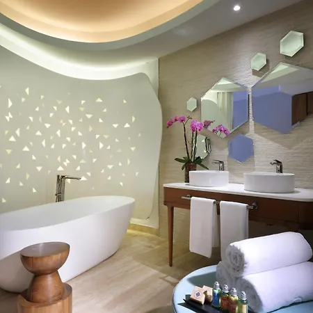 Trs Coral Hotel (Adults Only) Cancun Beds photo The photo shows a modern and luxurious bathroom with a focus on clean lines and a spa-like atmosphere. 

The main features include a sleek, white freestanding bathtub positioned against a curved, white wall. The wall is adorned with a subtle pattern 